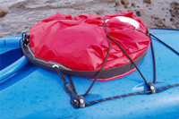 WindPaddle sail coiled and stowed flat on kayak deck